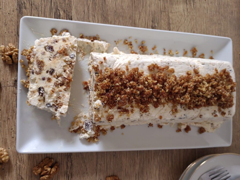 Semifreddo cu nuci caramelizate și stafide, văzut de sus, cu felie tăiată alături