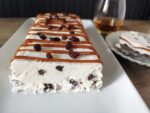 Semifreddo cu stafide și rom, felie tăiată, cu pahar de rom în fundal